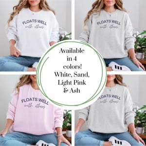 Cozy fleece crewneck with navy script print, styled for warm weather layering, float brunch, or lake house lounging.