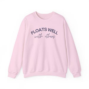 Light pink cozy float sweatshirt with playful message, perfect for matching lake day looks and relaxing boat rides.