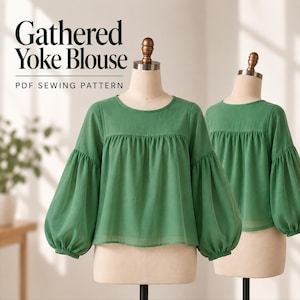 Peut inclure: Un chemisier vert avec des manches longues et volumineuses et un empiècement froncé, présenté sur deux mannequins. Le texte "Gathered Yoke Blouse PDF SEWING PATTERN" est imprimé en noir sur le côté supérieur gauche de l'image.