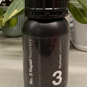 May include: Black bottle with a black cap. The bottle has white text that reads "No. 3 Rapid Recovery" and "Intensive Rehabilitation Solution". The number "3" is prominently displayed in white. The bottle contains 250ml.