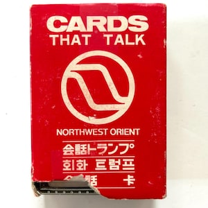May include: A red box of "CARDS THAT TALK" with the "NORTHWEST ORIENT" logo. The box has white text and a white logo. The box has some damage on the bottom left corner.