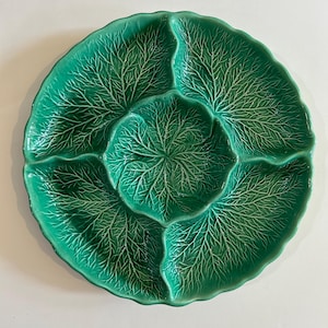May include: A green ceramic serving dish shaped like a cabbage leaf with four sections.
