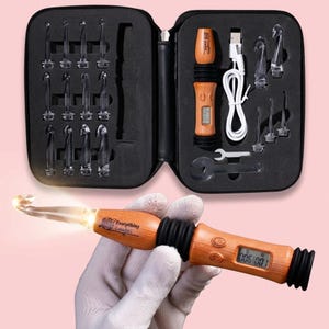 May include: A crochet hook set with a wooden handle and a clear, illuminated hook. The set includes various hook sizes, a digital counter, and a USB charging cable, all stored in a black zippered case. The hook in use is held by a gloved hand.