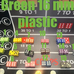 May include: A collection of sixteen 16 mm plastic dice in various colors, including green, yellow, orange, black, pink, brown, purple, blue, and white, arranged on a casino-style game board. The text "Green 16 mm plastic" is displayed at the top.
