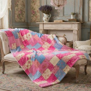 May include: A patchwork quilt in shades of pink, blue, and cream, draped over a white upholstered chaise lounge. The quilt features floral and gingham patterns. The room has a vintage aesthetic with a rug and antique furniture.