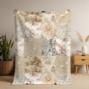May include: A rectangular throw blanket featuring a patchwork design of various toile de jouy patterns in shades of beige, brown, cream, and grey. The fabric displays intricate illustrations of floral arrangements, trees, and architectural structures.