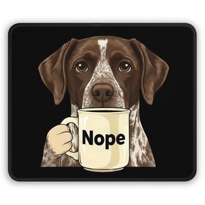 May include: A mousepad featuring a brown and white dog holding a cream-colored mug. The mug has the word "Nope" in bold black letters. The dog has brown eyes and a white patch on its head, set against a black background.