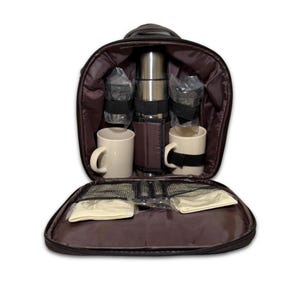 May include: Open picnic backpack with a stainless steel thermos, two white mugs, two clear plastic cups, and two cream-colored napkins. The interior is lined with a dark brown fabric. The backpack has a black handle.