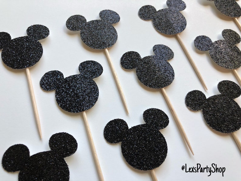 Pode incluir: Toppers para cupcakes com cabe&ccedil;a de Mickey Mouse de glitter preto. Os toppers est&atilde;o em palitos de madeira e s&atilde;o perfeitos para uma festa de anivers&aacute;rio ou outra celebra&ccedil;&atilde;o.