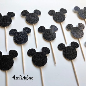 Pode incluir: 12 toppers para cupcake com cabe&ccedil;a de Mickey Mouse preta com glitter em palitos de madeira.