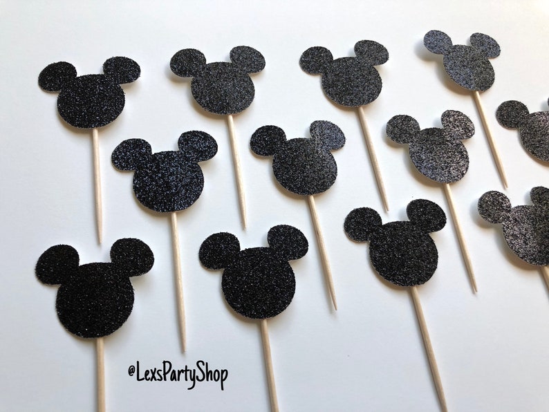 Pode incluir: 12 toppers para cupcake com cabe&ccedil;a de Mickey Mouse preta com glitter em palitos de madeira.