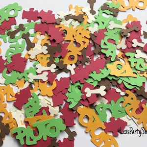 May include: A pile of colorful confetti featuring the word "RUFF" in green, red, and orange, along with bone-shaped confetti in brown and white. The confetti is perfect for a dog-themed party.