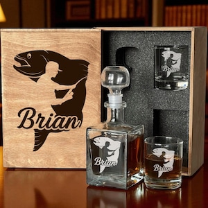 May include: A wooden gift box set with a decanter and two glasses. The box features a fish and fisherman silhouette with the name "Brian". The decanter and glasses also have the same design and name.
