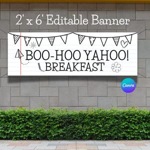 May include: A rectangular banner, 2 feet by 6 feet, with the text "BOO-HOO YAHOO! BREAKFAST" in a playful font. The banner has a white background with a lined paper design and decorative doodles. A string of pennants hangs above the text.