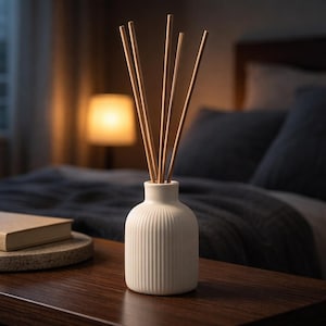 May include: A handmade wooden sign with the text "Welcome to our home" in a handwritten style. The sign is painted white with a dark stained wooden frame. A small green plant is placed on the sign.