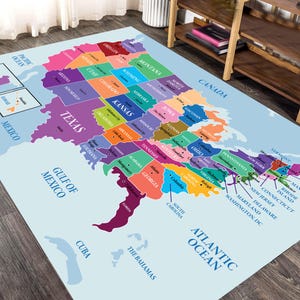 May include: A rectangular area rug featuring a colorful map of the United States. Each state is depicted in a distinct solid color with its name and capital city printed in black text. The map includes labels for the Atlantic Ocean, Gulf of Mexico, Canada, Mexico, Cuba, and The Bahamas.