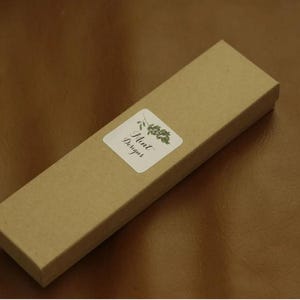 May include: A brown cardboard box with a white label that says "Mint Designs" and a green leaf design.