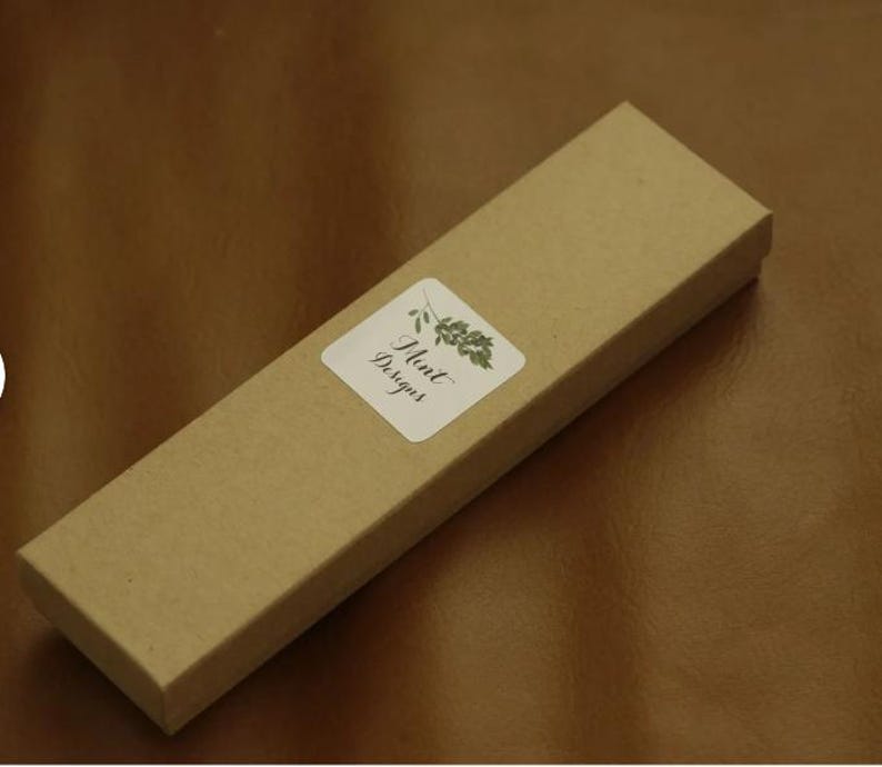 May include: A brown cardboard box with a white label that says "Mint Designs" and a green leaf design.
