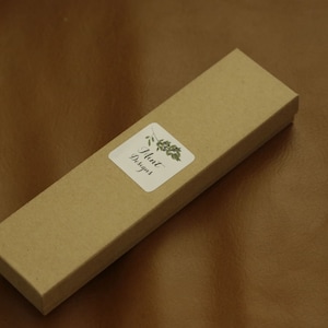 May include: A brown cardboard box with a white sticker that says "Mint Designs" and a green leaf design.