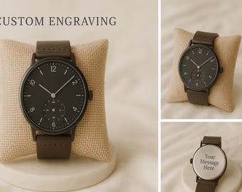 Könnte beinhalten: Eine schwarze Armbanduhr mit braunem Lederarmband. Das schwarze Zifferblatt hat weiße Ziffern und Zeiger. Der Text "CUSTOM ENGRAVING" steht oben. Die Uhr wird auf einem beigen Kissen präsentiert.