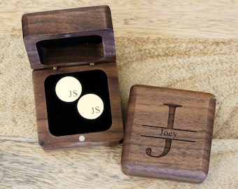 May include: A wooden box with a hinged lid, engraved with the letter "J" and the name "Joey". The box is open, revealing a black velvet interior with two gold cufflinks engraved with the initials "JS".