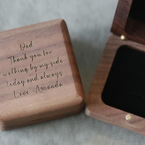 May include: A wooden box with a hinged lid. The lid is engraved with the message "Dad. Thank you for walking by my side today and always. Love. Amanda".