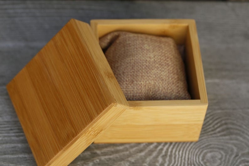 Puede incluir: Una caja de madera con tapa, la caja est&aacute; abierta y el interior est&aacute; forrado con una tela marr&oacute;n. La caja es de madera marr&oacute;n claro.