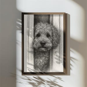 May include: A framed pencil drawing of a dog's head peeking through a wooden fence. The dog has curly fur and a gentle expression. The artwork is in a wooden frame and is displayed on a white wall.