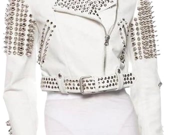 May include: White leather jacket with silver studs and spikes. The jacket features a notched collar, a zip-up front, and a studded belt. The shoulders and sleeves are heavily embellished with silver spikes, creating a bold, edgy look.