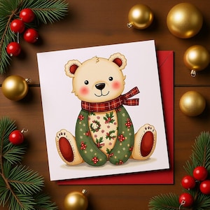 Peut inclure: Une carte de Noël avec un ours en peluche de dessin animé portant une écharpe à carreaux rouge et un manteau vert orné de houx et de baies. La carte est sur une enveloppe rouge, entourée de boules dorées, de baies rouges et de branches de pin sur une surface en bois.