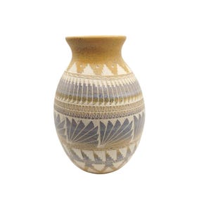 May include: A handcrafted ceramic vase with a bulbous body and a narrow neck. The vase features a tan rim and a body decorated with geometric patterns in shades of blue, tan, and white. The vase is approximately 8 inches tall.