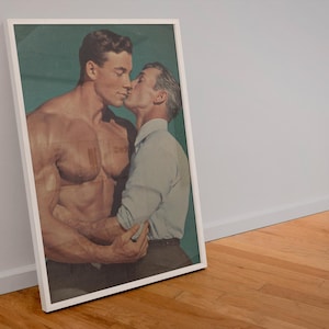 May include: A framed print featuring two men in a tender embrace. One man is muscular and shirtless, while the other wears a light blue button-down shirt. The background is a muted teal, and the frame is white.