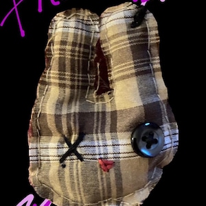 Op de afbeelding: Een handgemaakt pluche konijn in een bruin en beige ruitpatroon. Het konijn heeft een zwart knoopoog, een gestikte zwarte 'X' als mond en een rood hart. De naam "Phoebe" staat in roze geschreven.