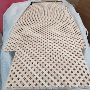 a wooden lattice with a grid pattern, wrapped in bubble wrap and placed on a surface.