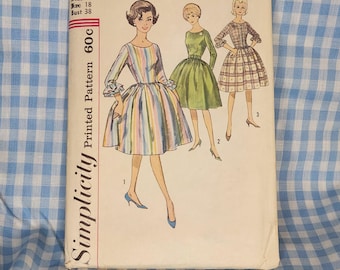 May include: Vintage Simplicity printed sewing pattern, number 4573, featuring illustrations of three dresses. The cover shows a woman in a striped dress, a green dress, and a plaid dress. The pattern is for Miss size 18, bust 38.