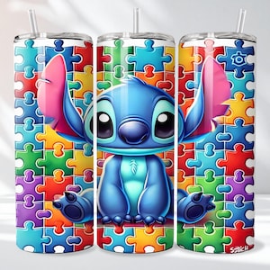 May include: A stainless steel tumbler featuring a colorful puzzle pattern and a cartoon character. The character is blue with large black eyes, pink ears, and is sitting on a puzzle piece background. The tumbler includes a straw.
