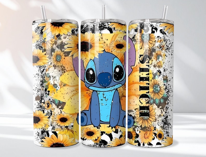 May include: A tumbler featuring a blue cartoon character with large eyes, surrounded by yellow sunflowers. The design includes the word "Stitch" in black vertical text, set against a white and black speckled background. A straw is visible.