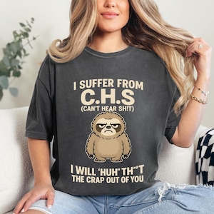 May include: Dark gray t-shirt with the text "I SUFFER FROM C.H.S (CAN'T HEAR SHIT)" and a cartoon sloth. The shirt also says "I WILL 'HUH' TH'T THE CRAP OUT OF YOU". The word "Pepper" is at the bottom.