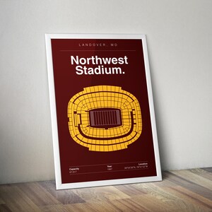 May include: A framed poster with a maroon background features a yellow stadium layout. The text "Northwest Stadium" is displayed in white. Additional text includes "Landover, MD," "Capacity 67,617," "Year 1997," and location coordinates.