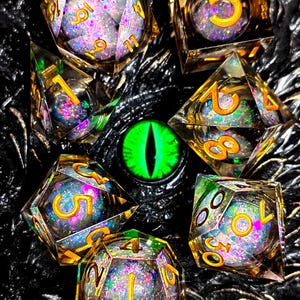 May include: A collection of iridescent, multi-sided dice with gold numbering, filled with glitter, and set against a dark, textured background. A glowing green eye is in the center of the image. The dice are for tabletop gaming.