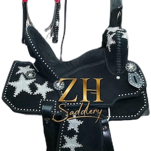 May include: Black western saddle with silver star detailing and studded trim. Includes a matching bridle, breast collar, and stirrups. The saddle features the text "ZH Saddlery" in gold.