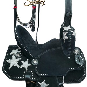 May include: Black western saddle set with silver star detailing. The set includes a saddle, bridle, breast collar, and matching accessories. The saddle features silver star conchos and decorative stitching, ideal for equestrian use.