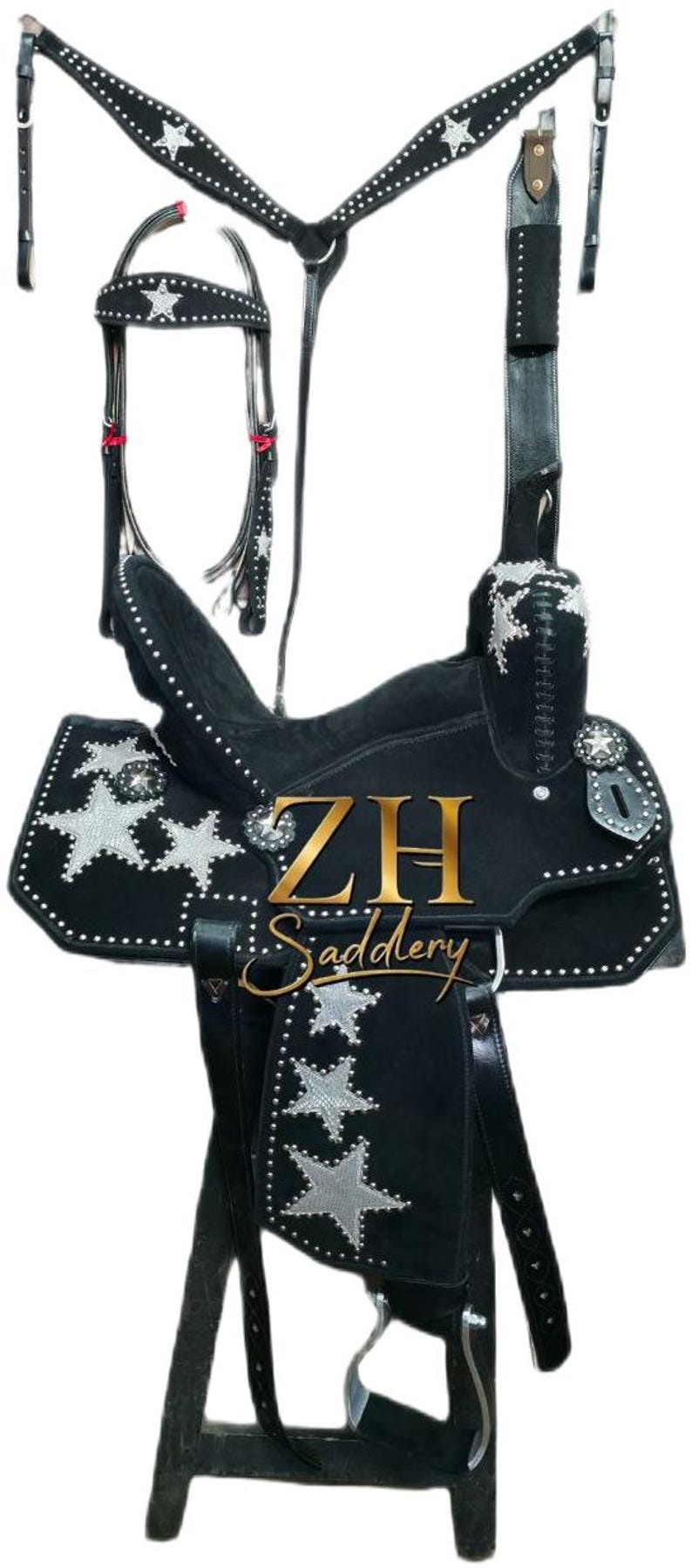 May include: Black western saddle with silver star detailing and studded trim. Includes a matching bridle, breast collar, and stirrups. The saddle features the text "ZH Saddlery" in gold.