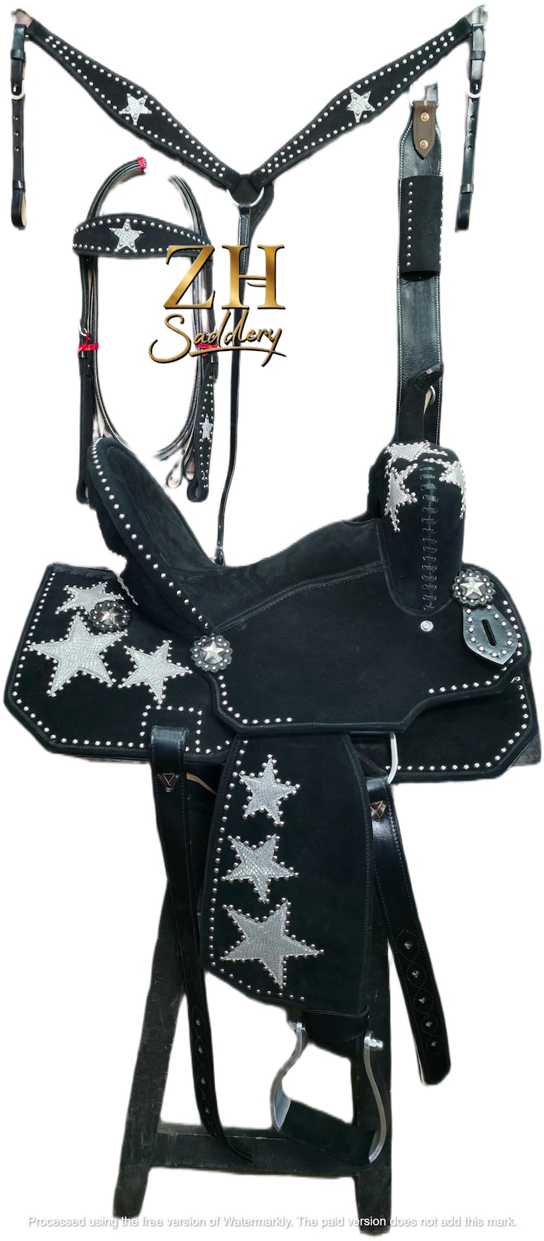 May include: Black western saddle with silver star detailing and white stud accents. Includes a matching bridle, breast collar, and stirrups. The saddle features a suede seat, designed for horseback riding.