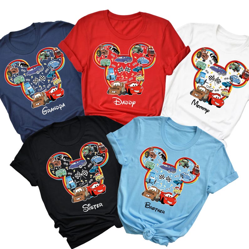 Puede incluir: Cinco camisetas coloridas con un dise&ntilde;o de cabeza de Mickey Mouse lleno de coches de dibujos animados. Las camisetas son azul marino, rojo, negro, blanco y azul claro. Cada camiseta tiene el nombre de un miembro de la familia: Grandpa, Daddy, Sister, Mommy y Brother.
