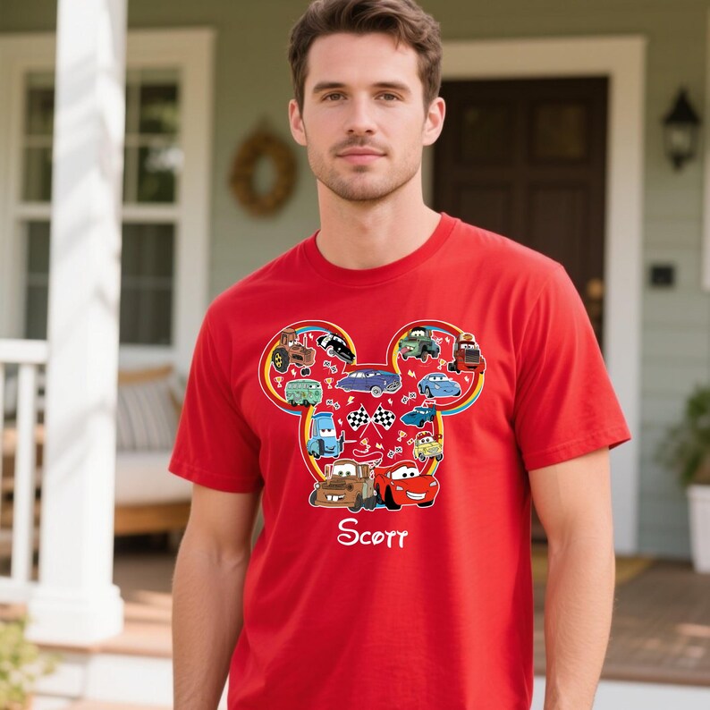 Puede incluir: Camiseta roja con un dise&ntilde;o en forma de Mickey Mouse lleno de coches de dibujos animados. El dise&ntilde;o incluye varias ilustraciones de coches y el nombre "Scott" en letra cursiva. La camiseta es de manga corta.