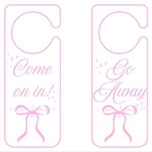May include: Two pink door hangers with the phrases "Come on in!" and "Go Away" in a decorative script, each featuring a bow and star accents. The hangers have a rounded top with a cutout for the door handle.