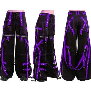 Könnte beinhalten: Schwarze Cargohose mit lila Akzenten, mit mehreren Taschen, Reißverschlüssen und Riemen. Die Hose hat einen Kordelzugbund und wird aus verschiedenen Blickwinkeln gezeigt, um die Designdetails hervorzuheben.