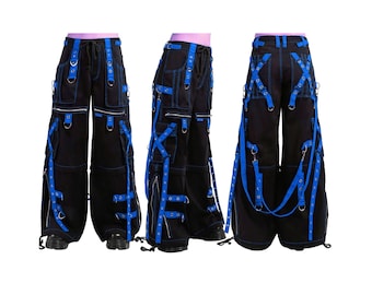 May include: Black cargo pants with blue accents, featuring multiple pockets, zippers, and straps. The pants have blue stitching and blue straps with metal rings. The design is visible from multiple angles.