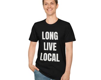 May include: Black t-shirt with the white text "LONG LIVE LOCAL" in a bold, sans-serif font. The shirt is worn by a person in blue jeans. The t-shirt is a casual wear item.